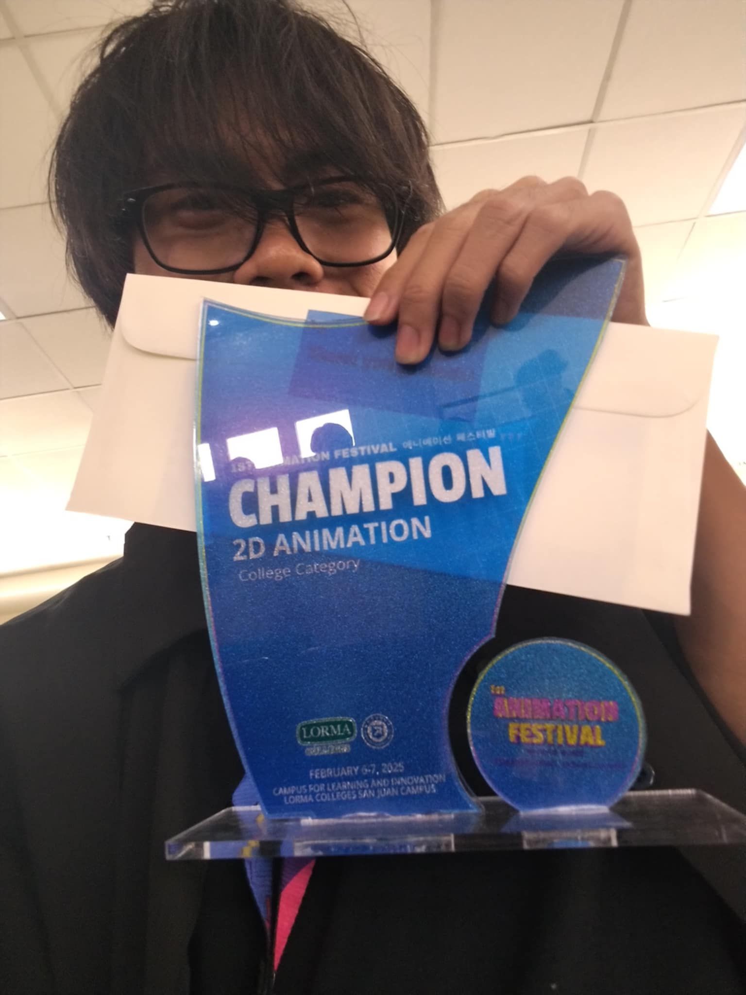 Jared with his Champion trophy for college-level 2D Animation